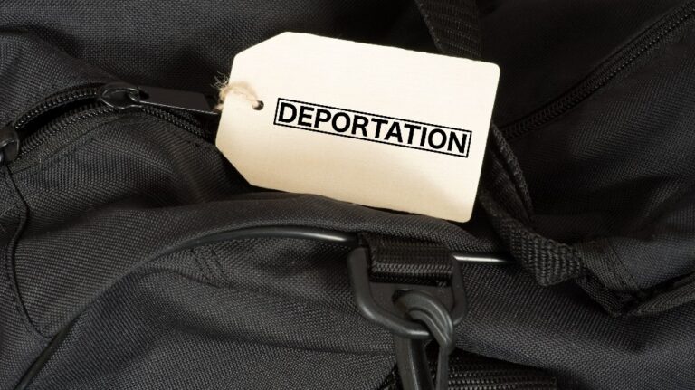 A bag and a sign with the word Deportation