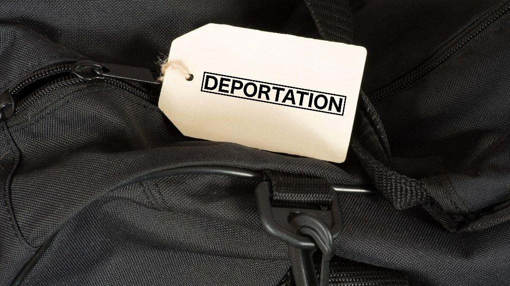 A bag and a sign with the word Deportation